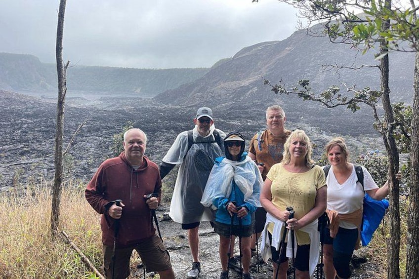 A group of people hiking on a trail with a mountainous landscape in the background. 4
