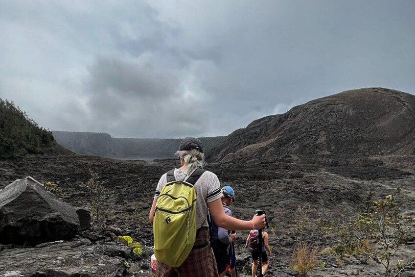 A hiker with a backpack and a child in a rocky terrain with hills in the background. 1