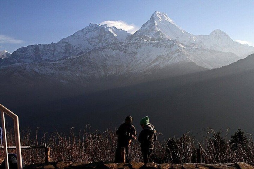 Two people standing on a mountain ridge overlooking a snow-capped peak. 3