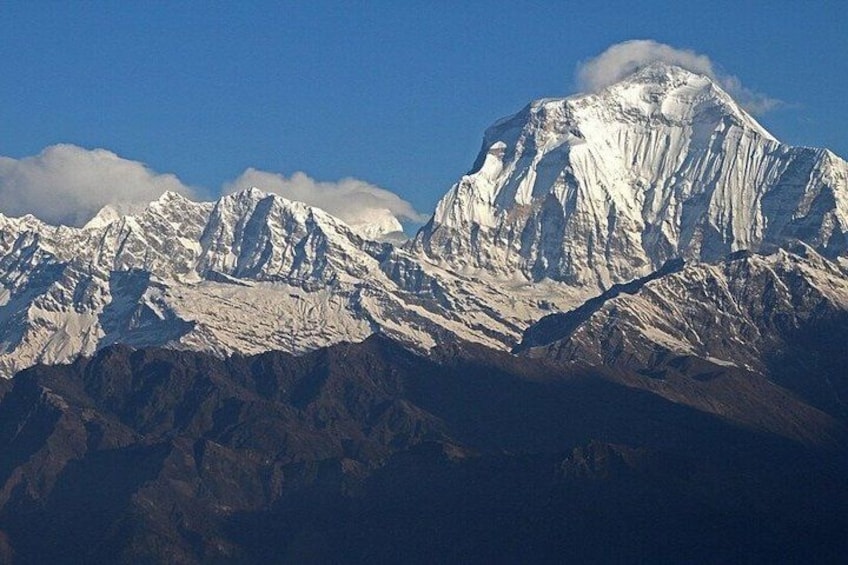 A snow-covered mountain range with rugged peaks and a clear sky. 2