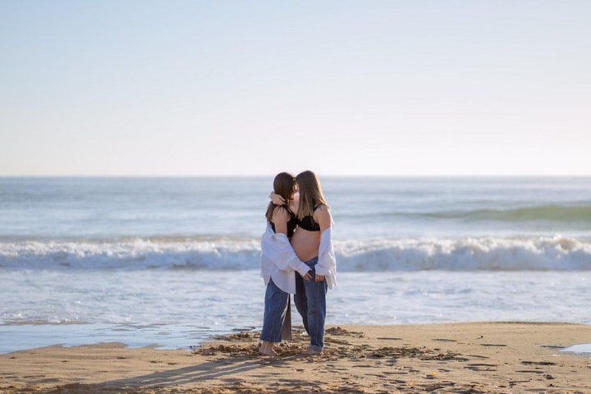 Two people embracing on a beach with ocean waves in the background. 3
