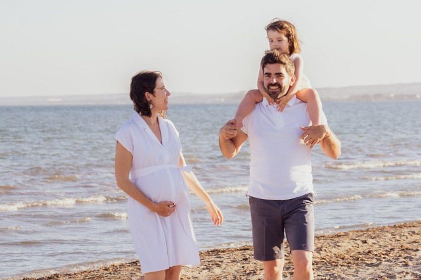 A family on a beach with a child on an adult's shoulders. 2