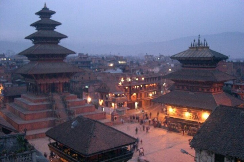 A traditional multi-tiered temple complex with illuminated structures at dusk. 5