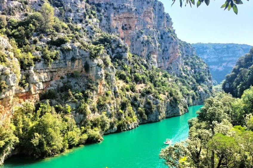A canyon with a turquoise river, steep cliffs, and dense greenery. 1