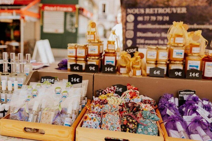 Un puesto de mercado con diversos artículos a la venta, incluyendo tarros de miel y saquitos de flores. 2