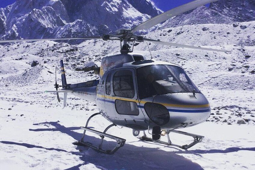 A helicopter on a snowy mountain with a clear sky. 5