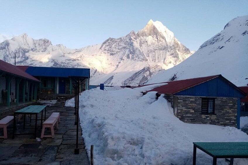 Une montagne enneigée, avec un chalet et une table au premier plan. 4