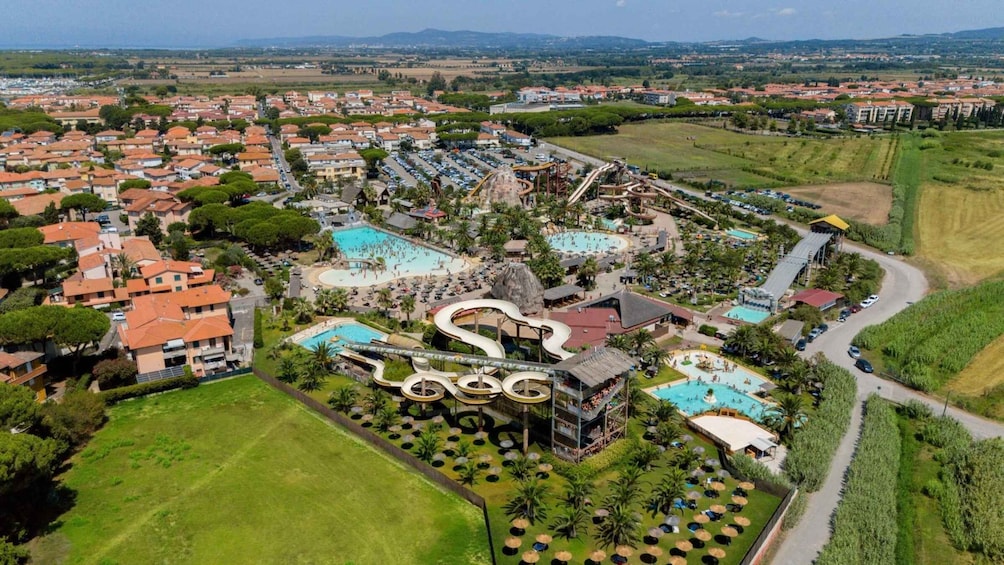An aerial view of a resort with multiple swimming pools, water slides, and a parking area. 2