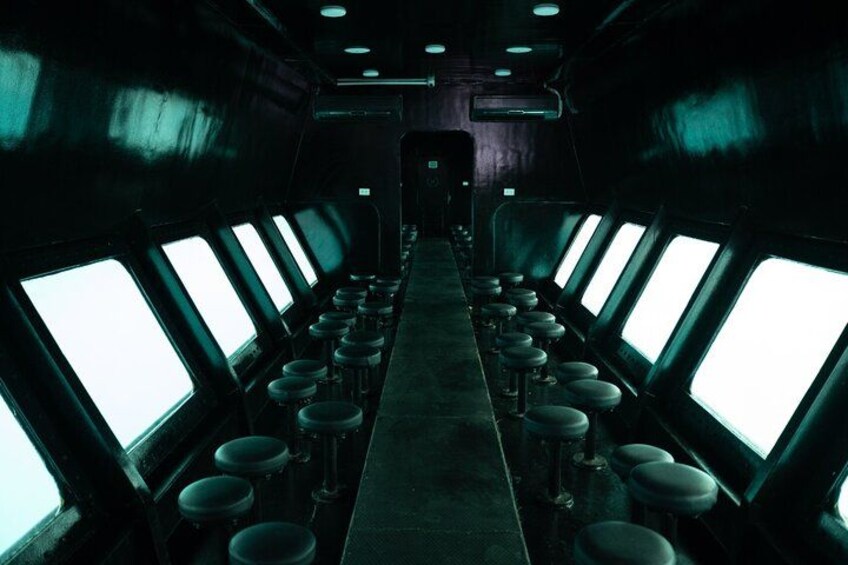 A long, narrow corridor with rows of windows on both sides and a central aisle. 3