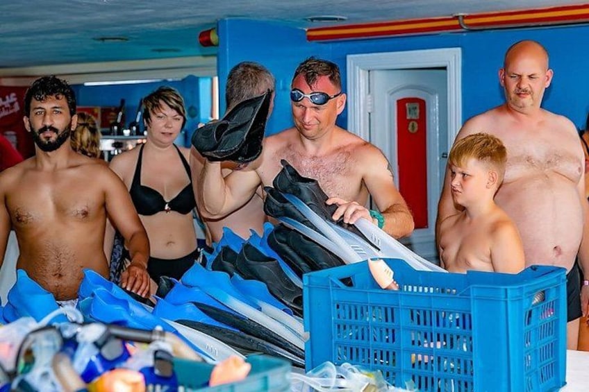 A group of people at a poolside with swimming gear and a blue crate. 5