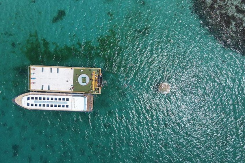 An aerial view of a boat docked near a rocky shoreline. 4