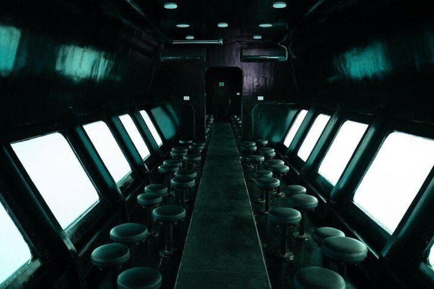 A narrow corridor with rows of windows on both sides and a central aisle. 3