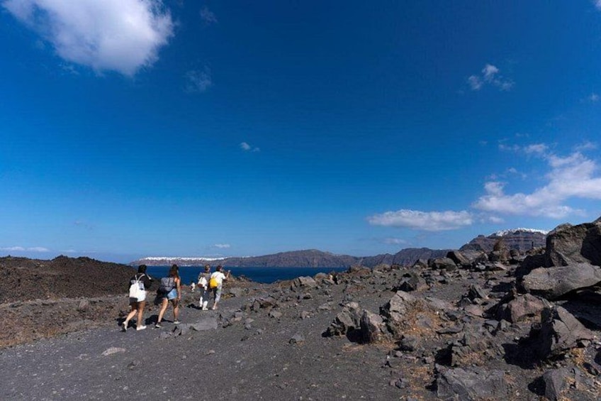 A group of people hiking on a rocky terrain with a clear sky. 3