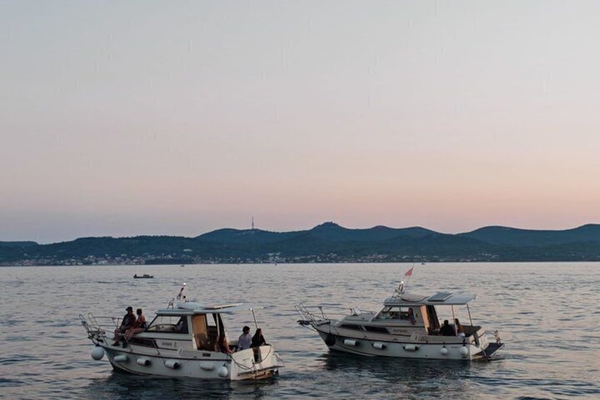 Two boats on calm water with a distant shoreline and hills. 2