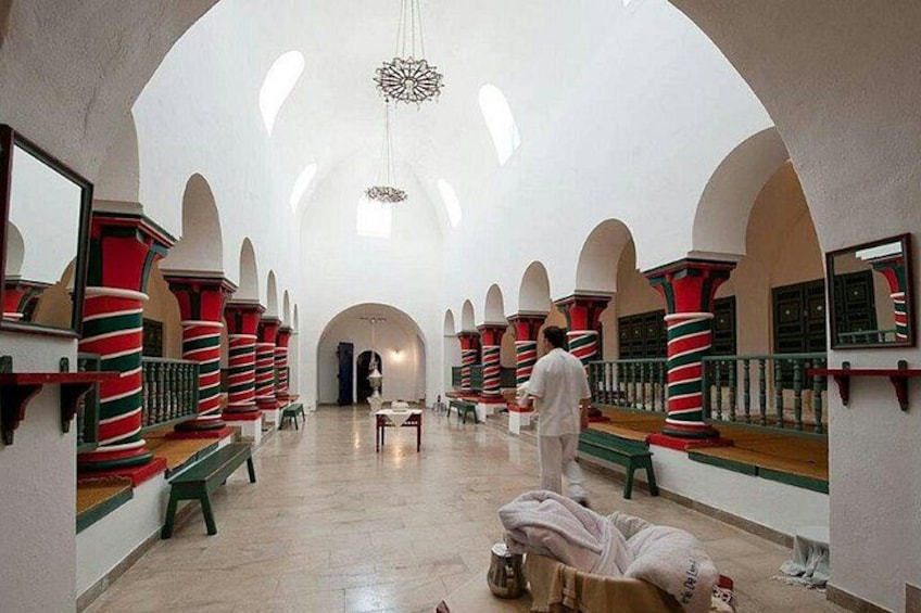 A spacious hall with high ceilings, arched alcoves, and striped columns. 3