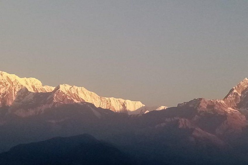 A mountain range with snow-capped peaks under a clear sky. 4
