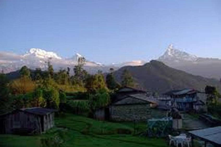 A mountainous landscape with a village, houses, and a prominent snow-capped peak. 3
