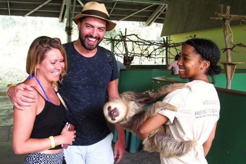 A person holding a sloth, a man in a hat, and two people embracing. 1