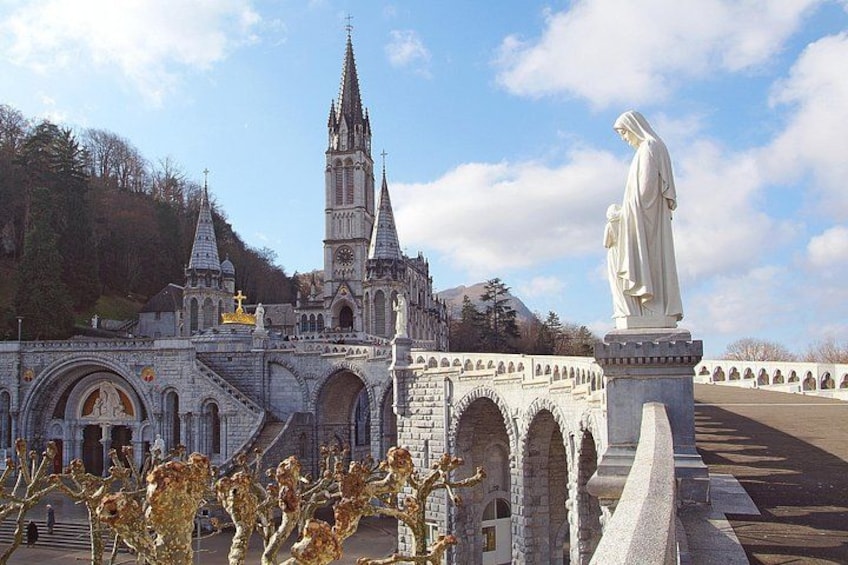 Une église historique, dotée d’un clocher imposant, d’une statue représentant une figure drapée et d’un pont en pierre. 2