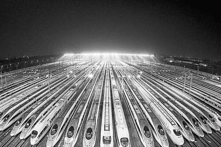 A nighttime aerial view of a train station with multiple tracks and trains parked in an orderly fashion. 3