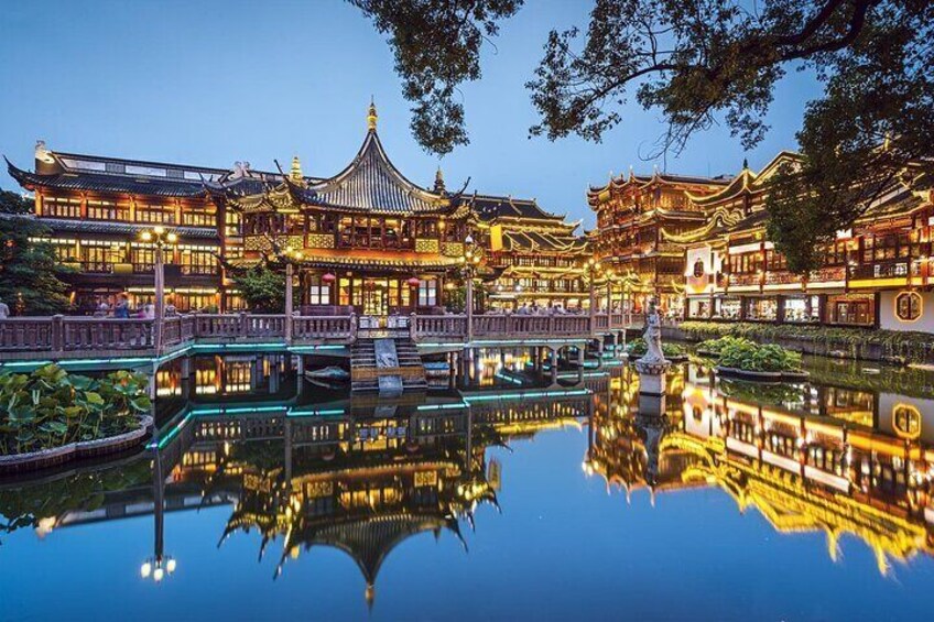 A traditional Chinese courtyard with ornate buildings, a reflective pond, and a statue in the center. 1
