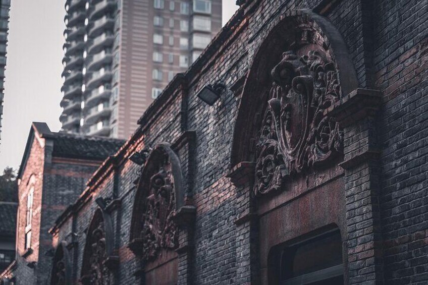A brick building with ornate carvings and a window. 2