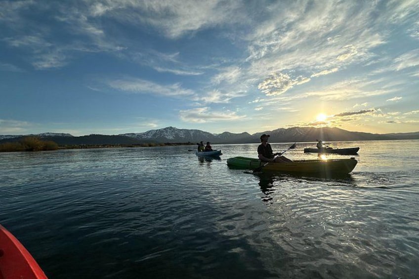 Kayakisti su un lago calmo con montagne sullo sfondo. 2