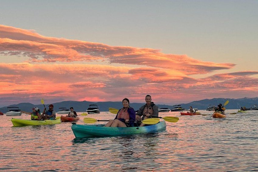 Persone che fanno kayak su un corpo d'acqua, con un tramonto sullo sfondo. 3