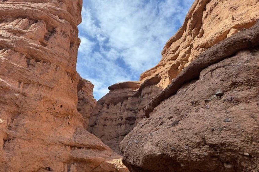 Eine Schlucht mit schichtartigen Gesteinsformationen und blauem Himmel. 2