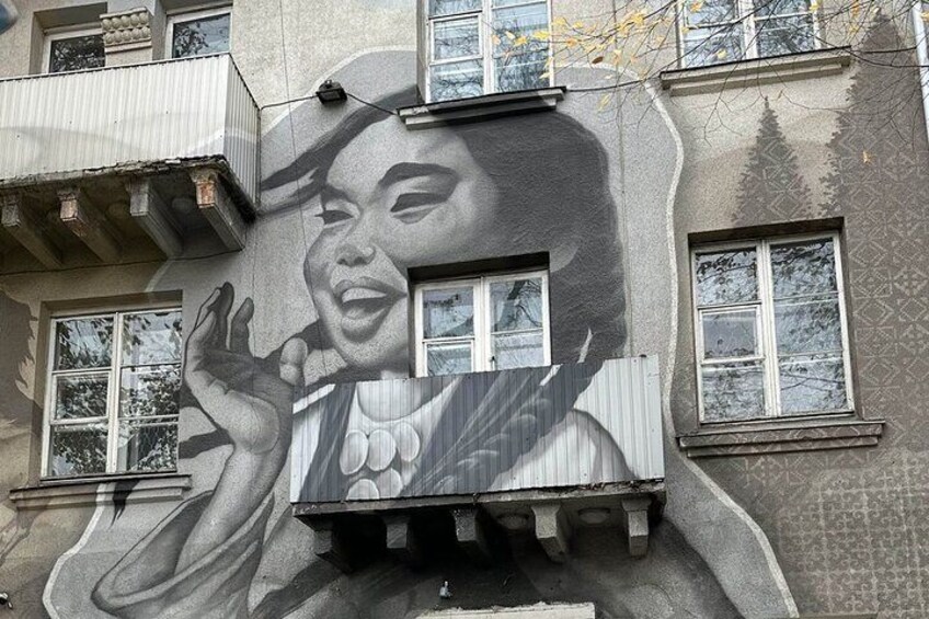 En bygning med et muralmaleri af en person, der holder en cigaret. 1