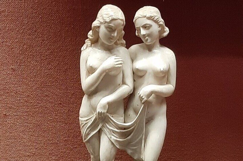 A white sculpture of two figures with draped clothing. 1