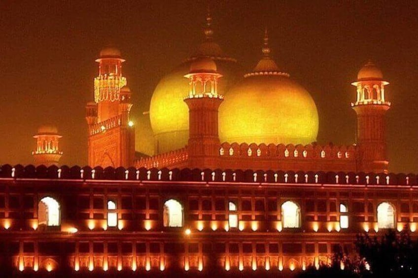 Un gran edificio iluminado con cúpulas y minaretes durante la noche. 1