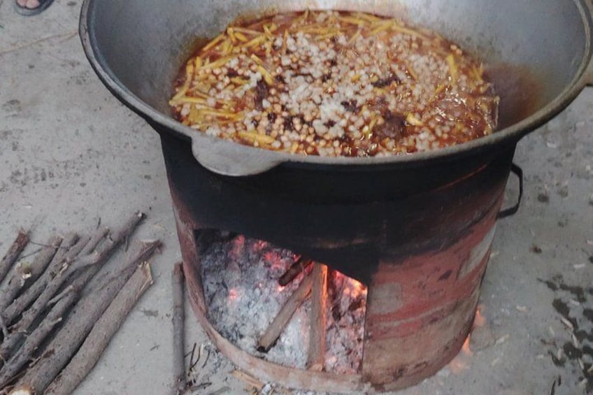 Ein Topf über offenem Feuer, in dem Essen zubereitet wird. 4