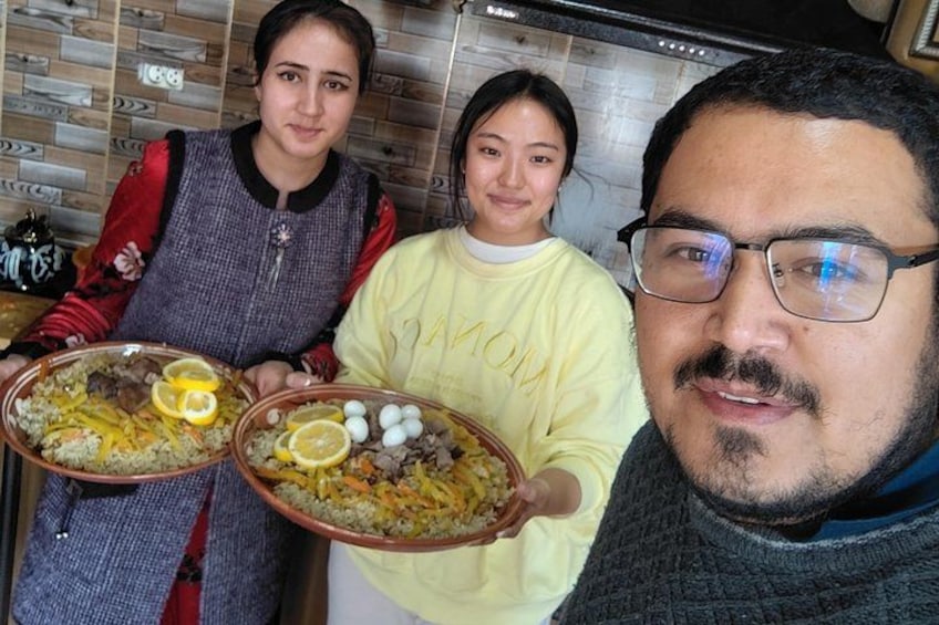 Three people holding large platters of food with lemon slices and eggs. 1