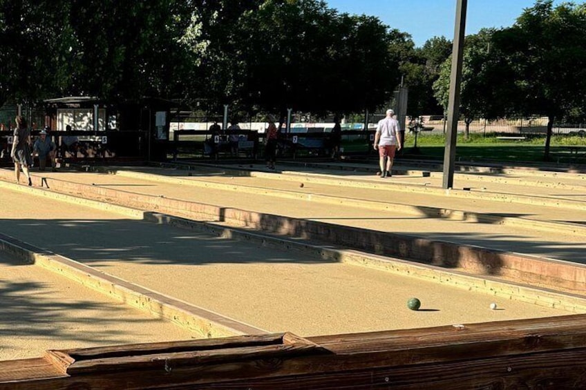 Un terrain de jeu de shuffleboard avec une personne qui s’éloigne de la caméra. 2