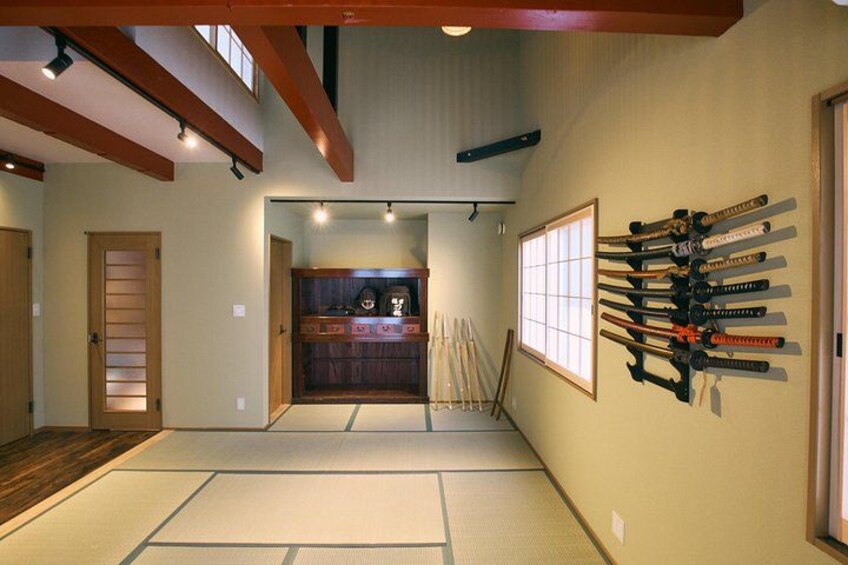 Un interior japonés tradicional con suelo de tatami, una puerta corredera y un perchero para esquíes en la pared. 3