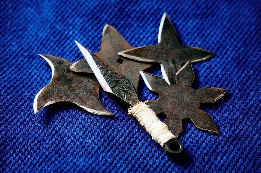 Tres medallas con forma de estrella y una espada sobre un fondo azul texturizado. 1
