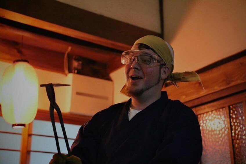Una persona sosteniendo una herramienta, usando un gorro, en una habitación con vigas de madera y una lámpara colgante. 4