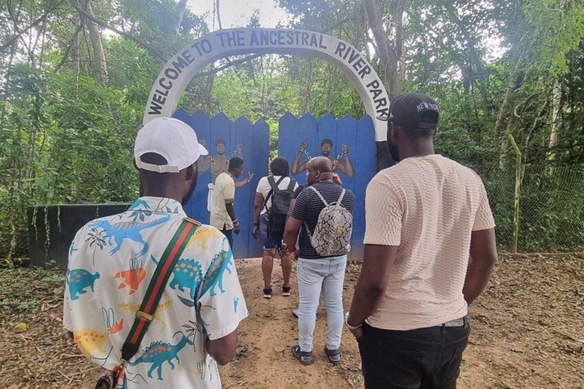 Personas entrando a un parque con un cartel que dice 'Bienvenido al Parque del Río Antiguo'. 1