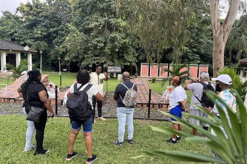 Un grupo de personas en un parque, con un cartel que dice 'Ancestral Graveyard'. 4