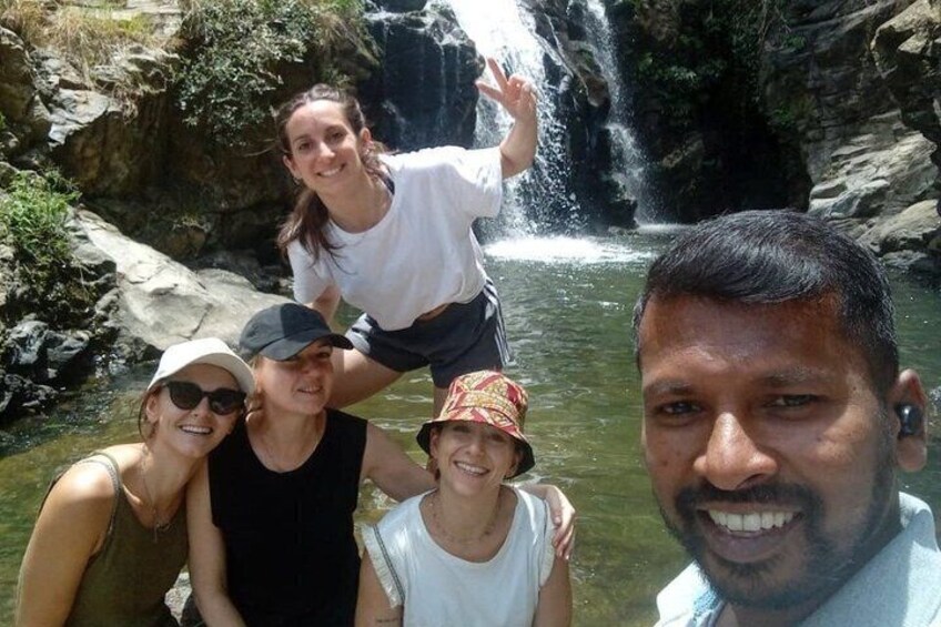 A group of people near a waterfall in a rocky terrain. 3