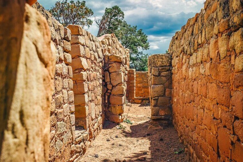 Ancient stone ruins with a narrow passageway and brick walls. 4