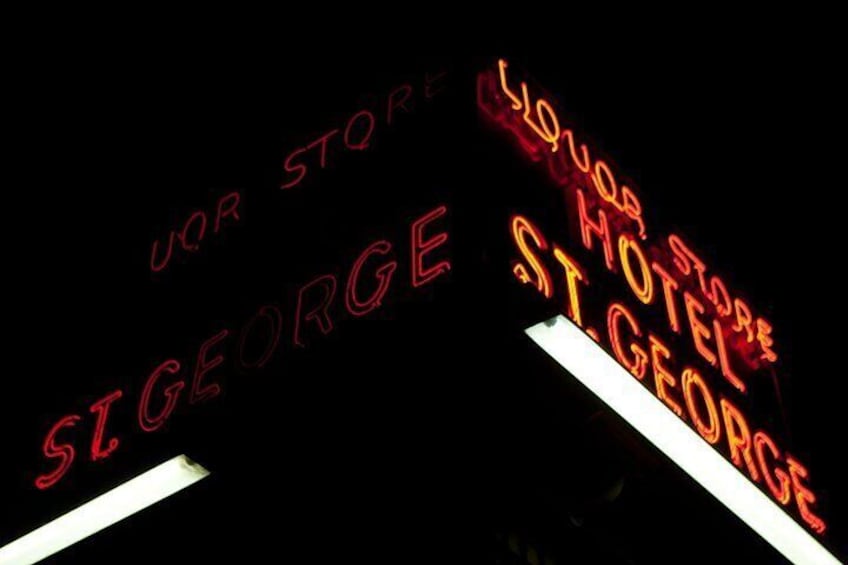 Neon signs for 'UOR STORE' and 'St. George Hotel' against a dark background. 5