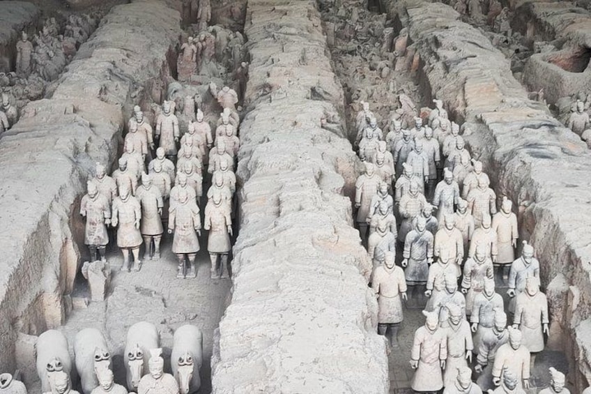 A large number of terracotta soldiers arranged in rows and columns, forming a massive underground army. 3