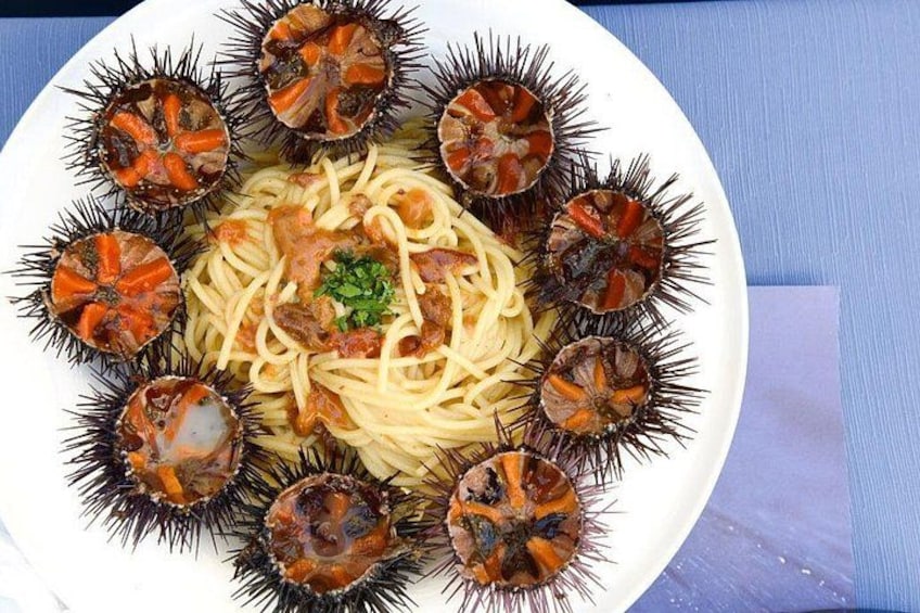 Een bord spaghetti met garnalen en zeesterrenschelpen. 2
