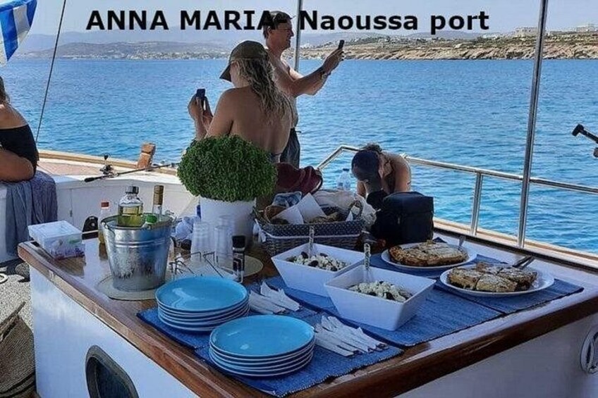 A boat with a table set for a meal, a person taking a photo, and a scenic view of the sea. 3
