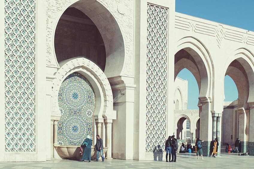 A large archway with intricate tile work and a clear blue sky. 2
