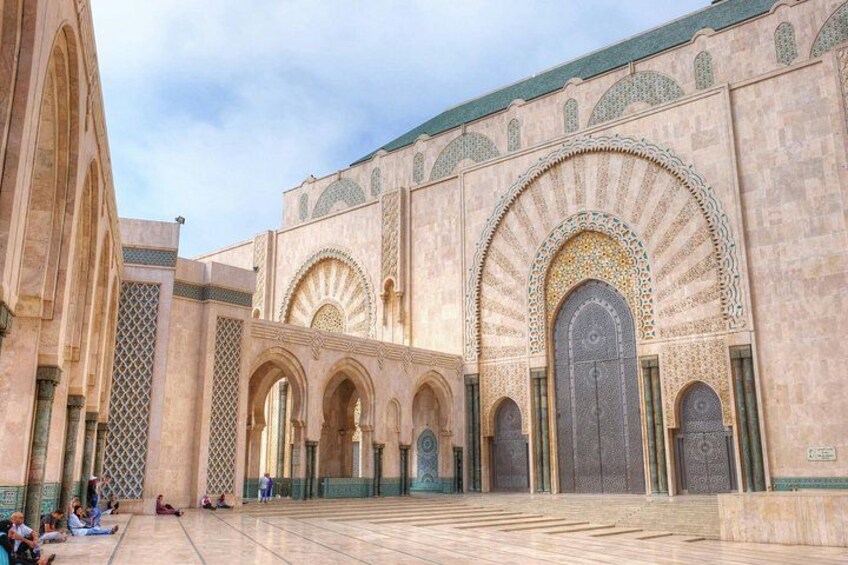 A courtyard with arches and a large door. 3