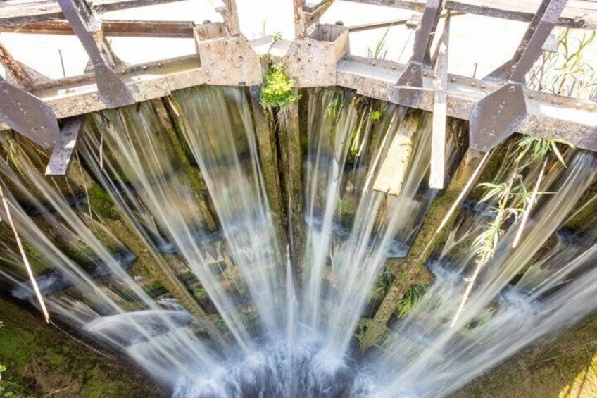 A water wheel with water flowing through its structure. 3