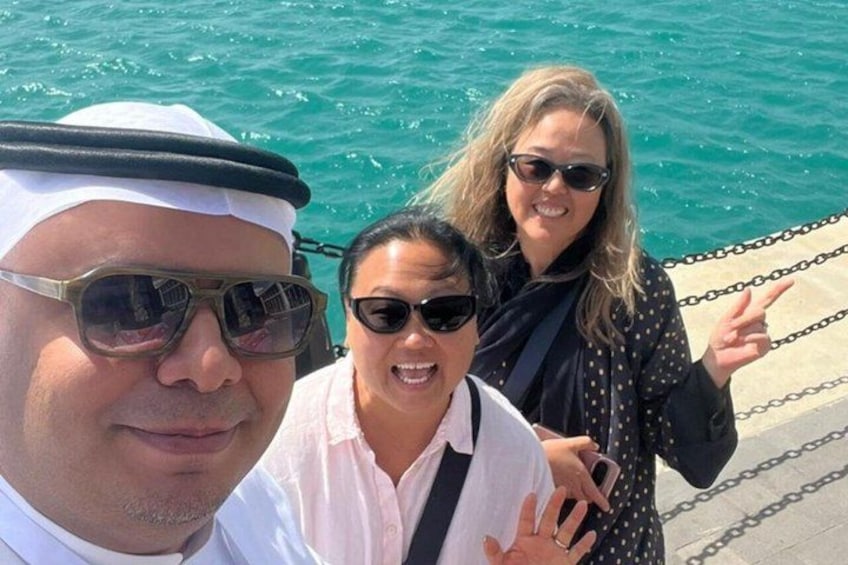 Three people near a body of water with a chain barrier. 3
